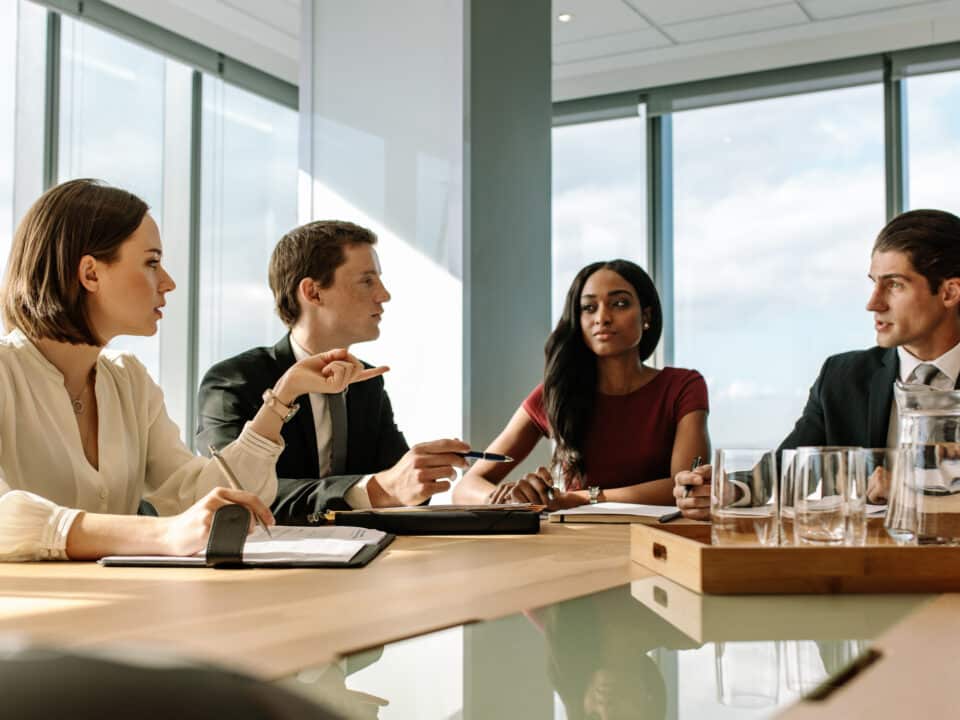 Four attorneys discussing transcription services in conference room