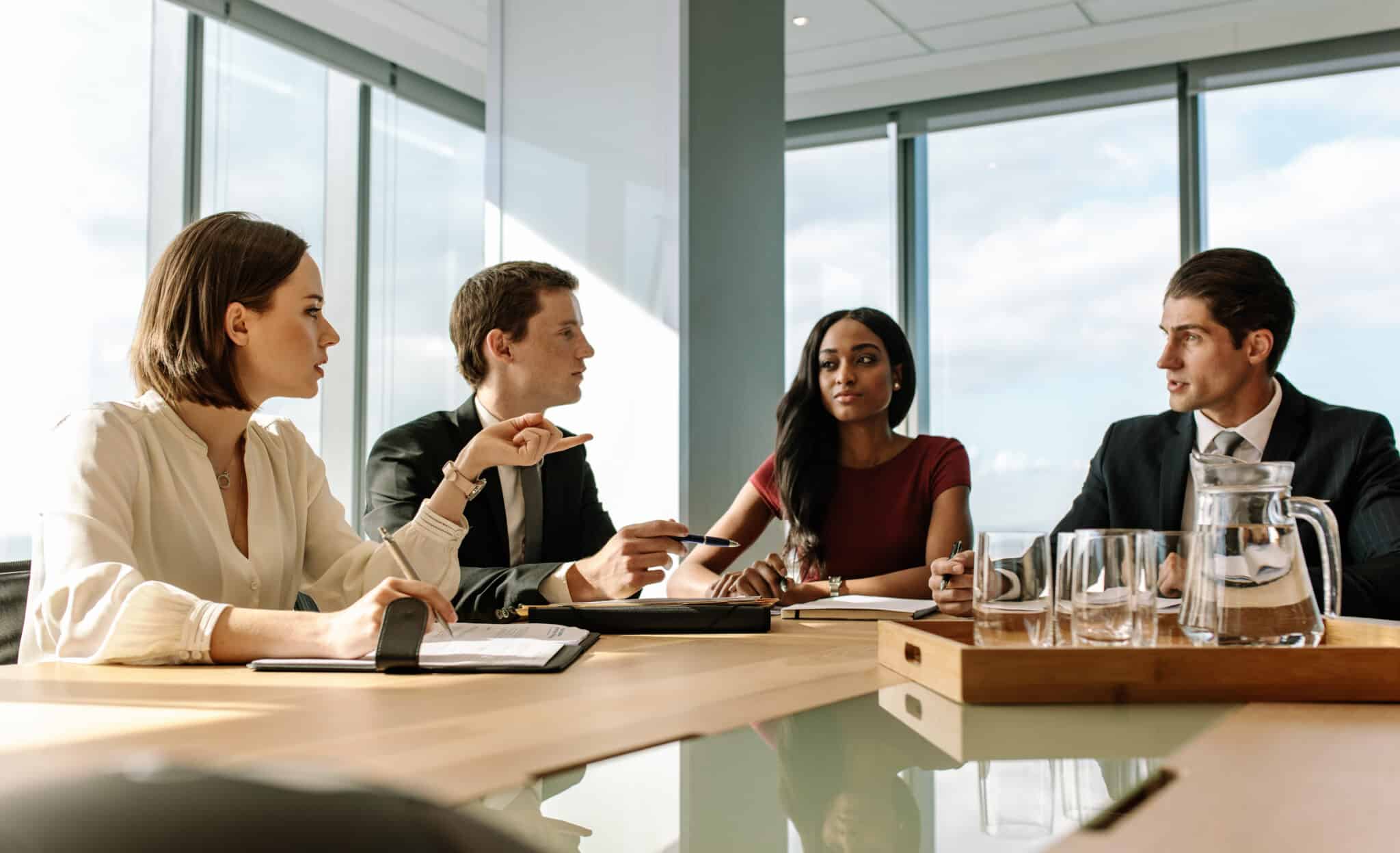 Four attorneys discussing transcription services in conference room