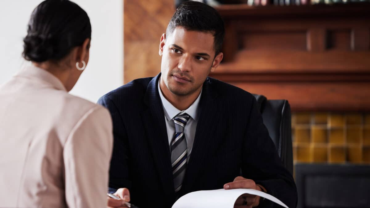 Attorney meets with his client in his office while recording the conversation for transcription