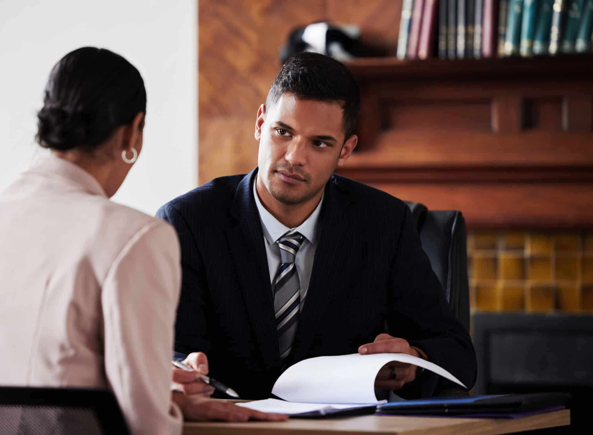 Attorney meets with his client in his office while recording the conversation for transcription