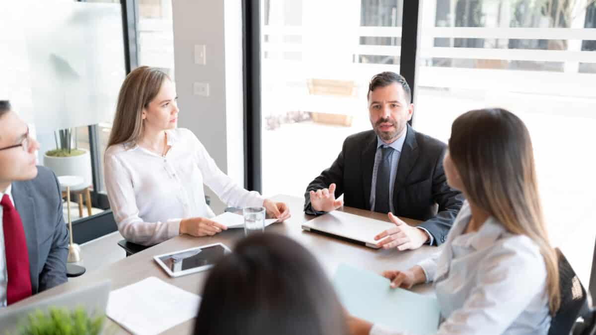 Corporate lawyer and executives leveraging legal transcription services during a strategy meeting.