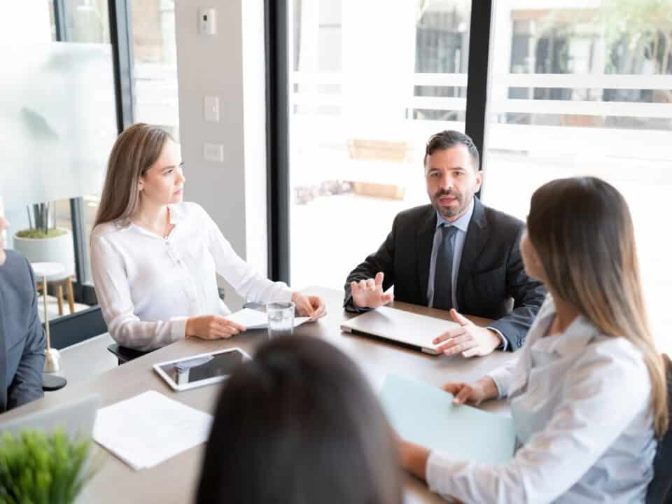 Corporate lawyer and executives leveraging legal transcription services during a strategy meeting.