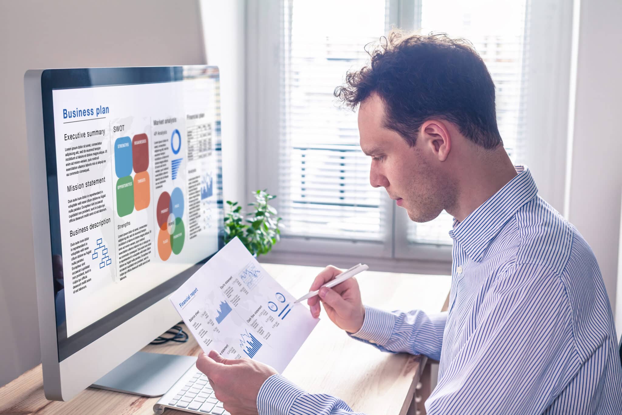 Businessman planning on computer, showing the role of finance transcription in business strategy.