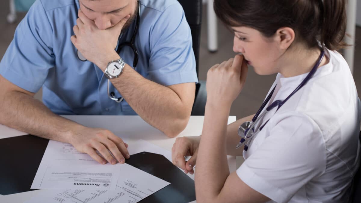 Doctor pondering inconsistencies in his EHR notes, highlighting the need for accurate records.