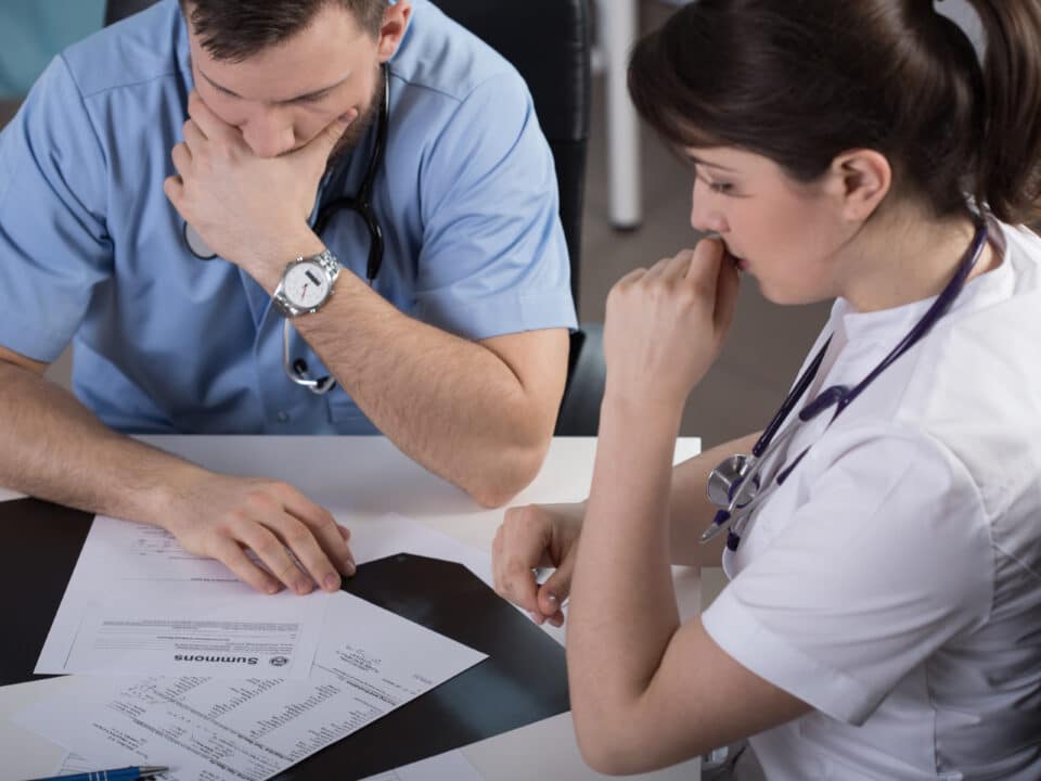 Doctor pondering inconsistencies in his EHR notes, highlighting the need for accurate records.