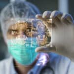 Surgeon analyzes digital hologram displaying patient's healthcare data from medical transcription.