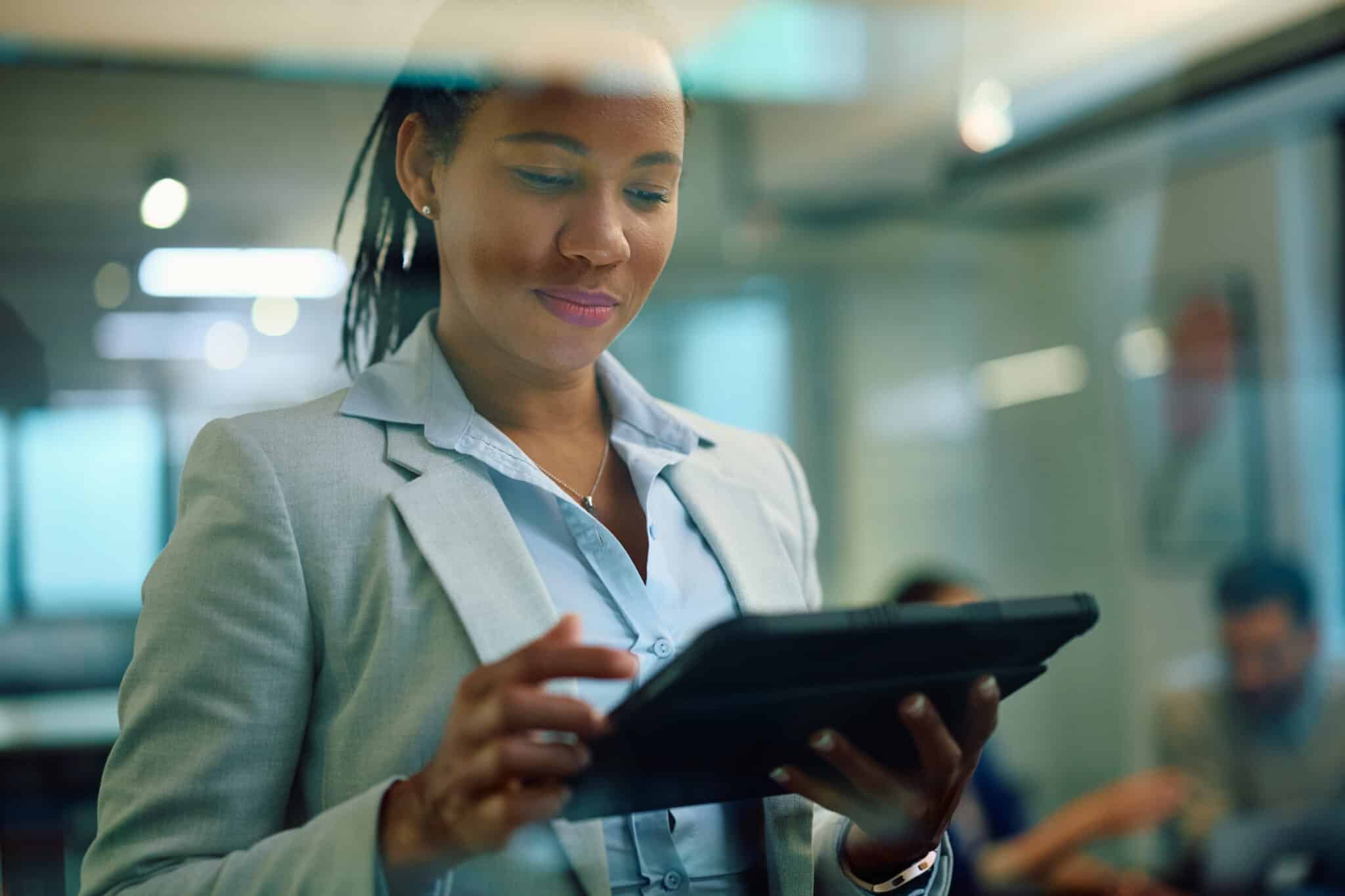 A bank manager reviews transcribed notes on her iPad to refresh her memory before a client meeting.