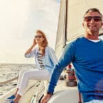 Happy couple sails on a yacht; symbolizes the peace of mind and freedom wealth managers give clients
