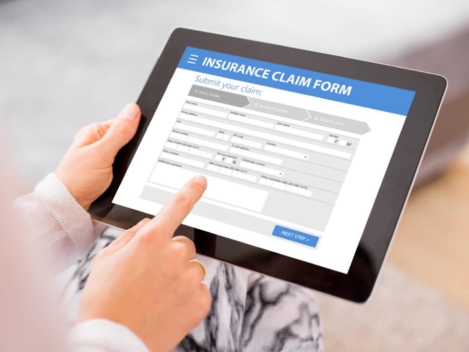 Insurance claim form displays on a tablet; transcription services help streamline claims processing.