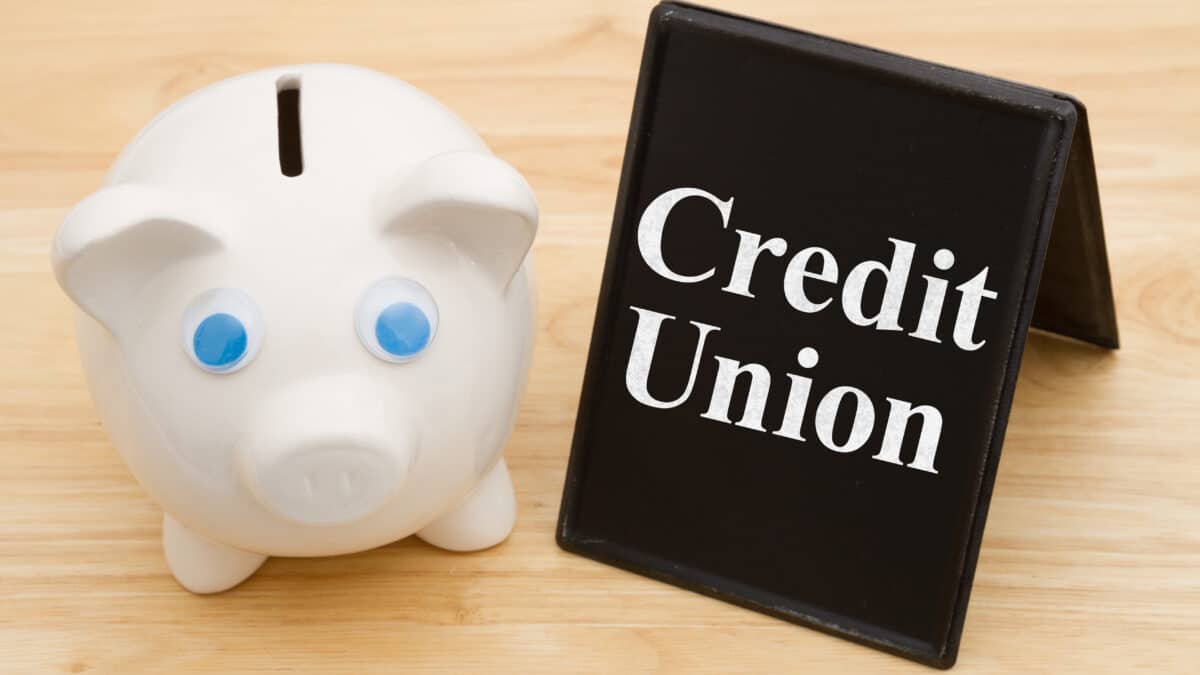 Piggy bank on a desk with 'Credit Union' sign, symbolizing transcription services in credit unions.