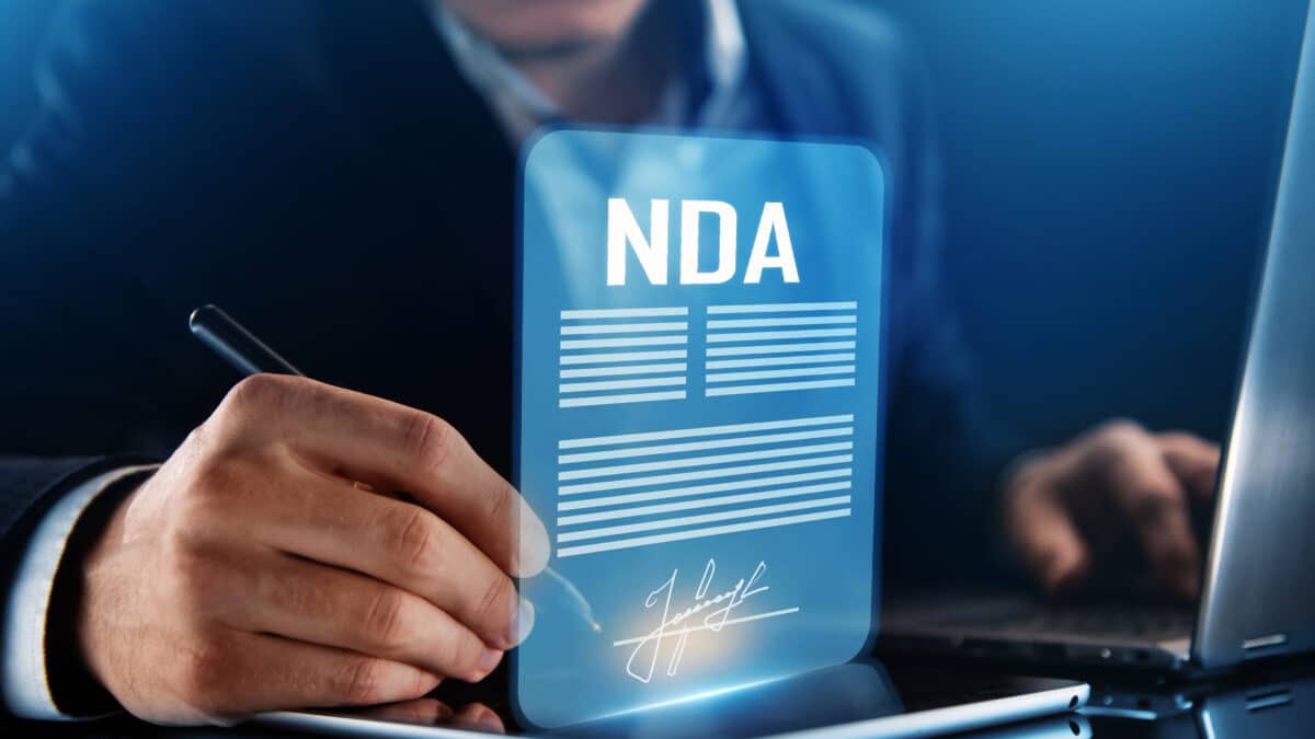 Man signs an NDA, symbolizing Athreon's commitment to confidentiality in transcription services.