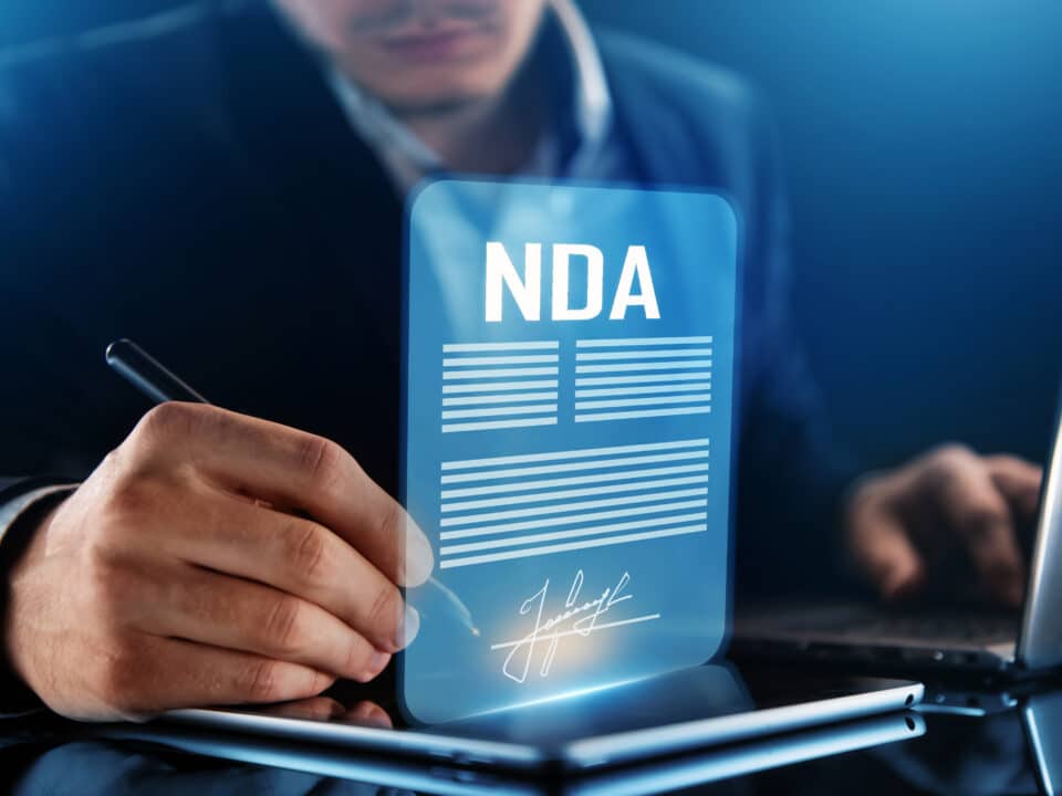Man signs an NDA, symbolizing Athreon's commitment to confidentiality in transcription services.