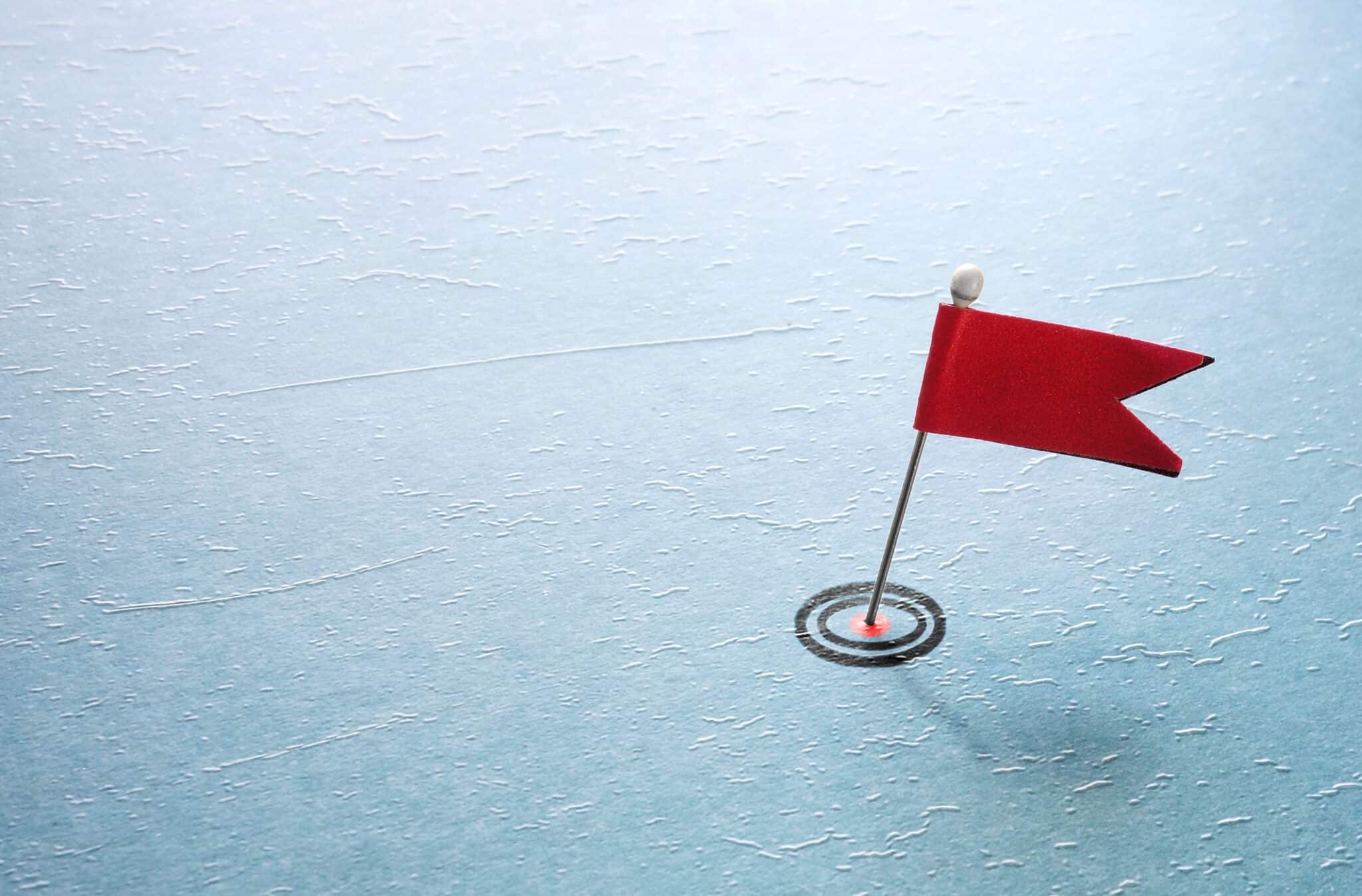 Pin target and red flag symbolize how transcription services help insurers manage fraud red flags.