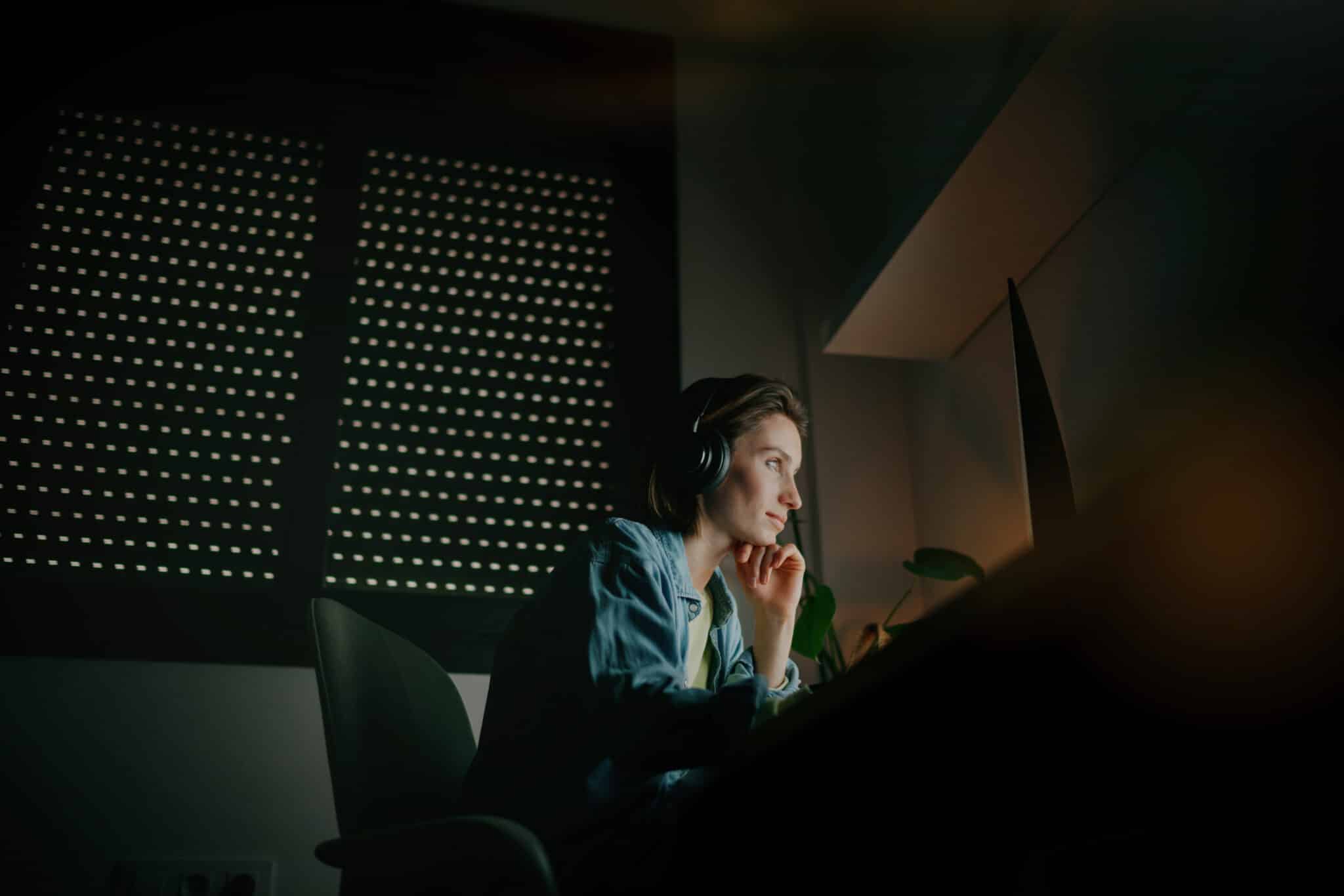 Athreon QA specialist wearing headphones diligently reviews transcripts during the overnight shift.