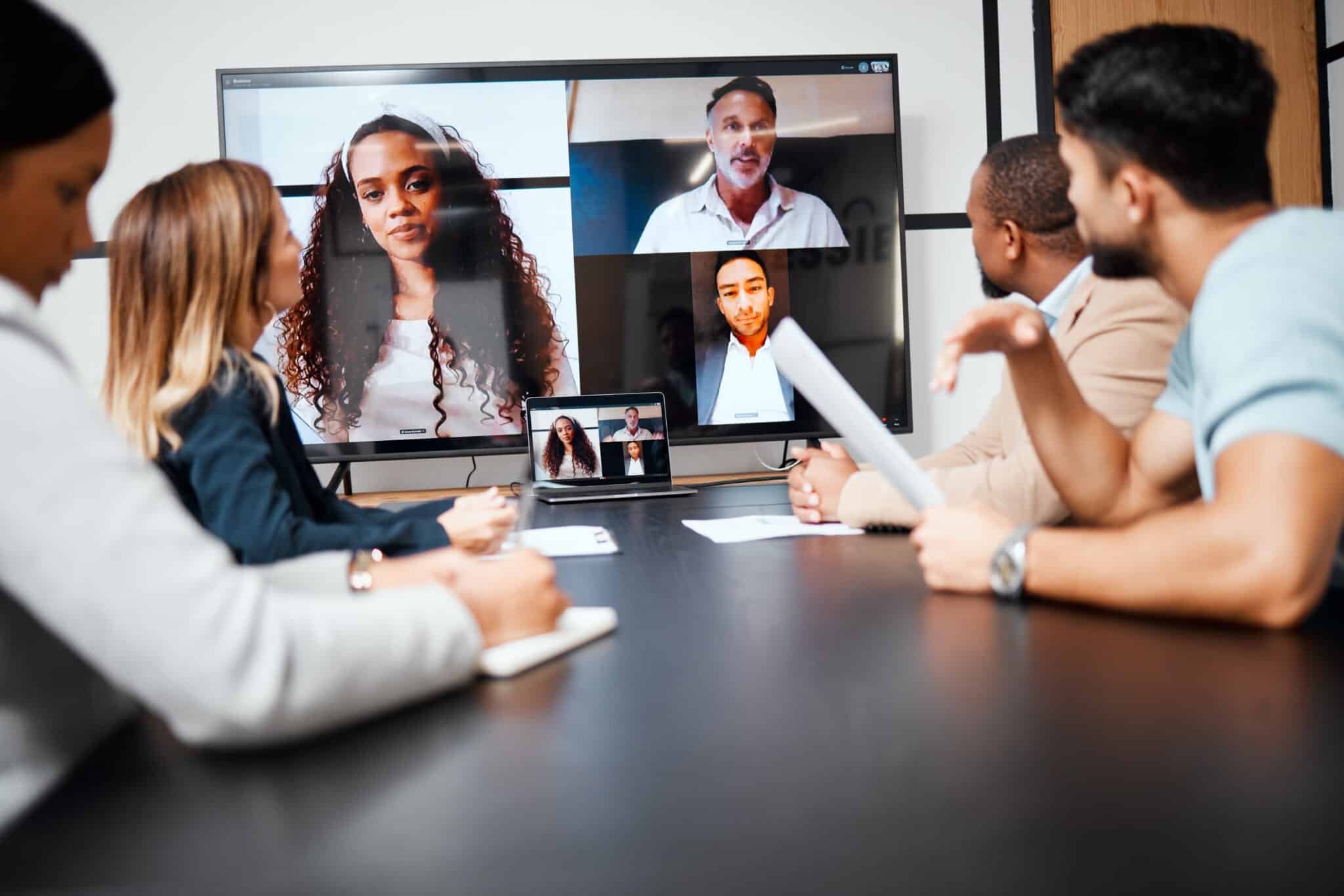 Business team strategizes in a virtual and in-person meeting, recorded for its transcription service