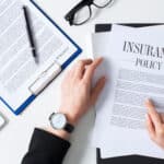 Businesswoman reviewing insurance policy documents for outsourced transcription services.