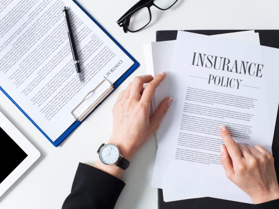 Businesswoman reviewing insurance policy documents for outsourced transcription services.