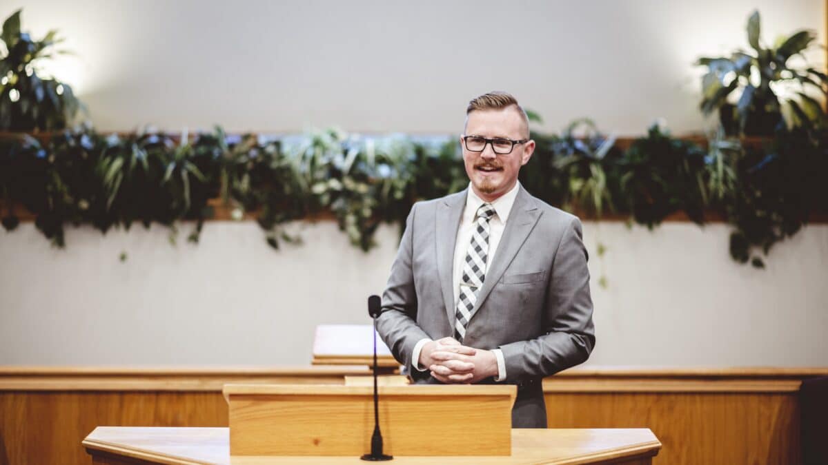 Man gives sermon in church, highlighting the utility of transcription services in religious settings