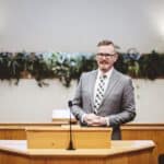 Man gives sermon in church, highlighting the utility of transcription services in religious settings