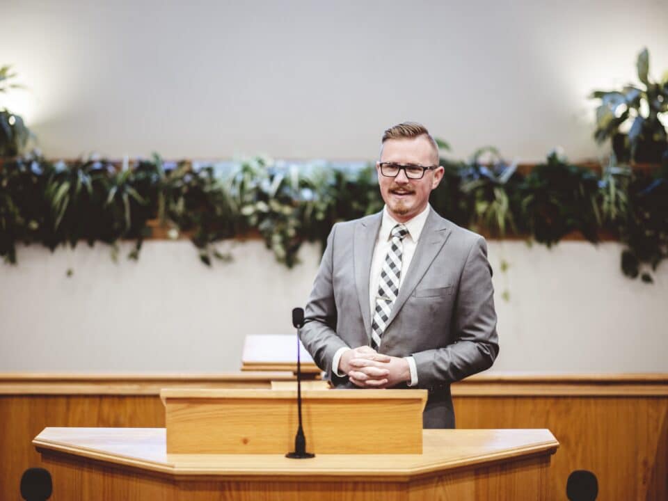 Man gives sermon in church, highlighting the utility of transcription services in religious settings