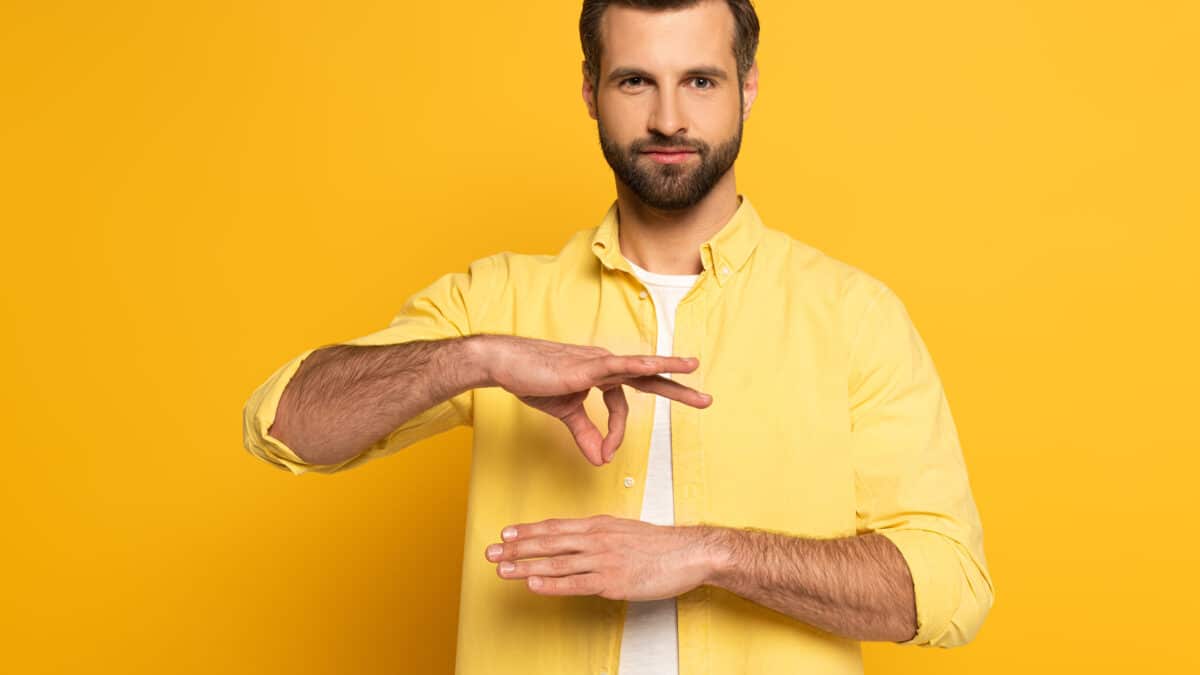 Man uses sign language, stressing accessible communication via video transcription services.