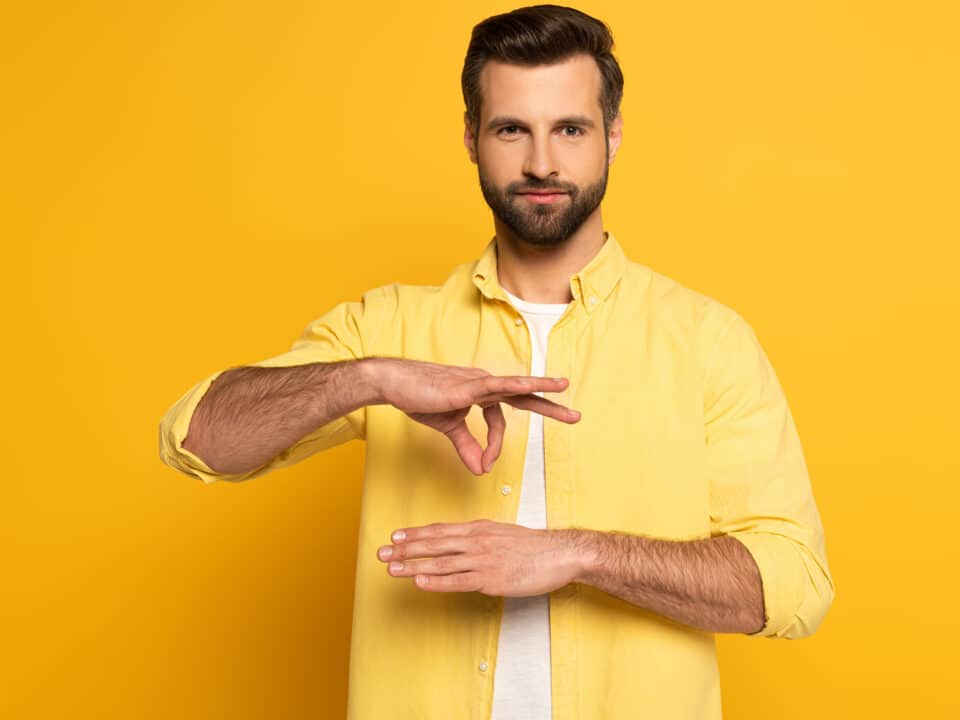 Man uses sign language, stressing accessible communication via video transcription services.