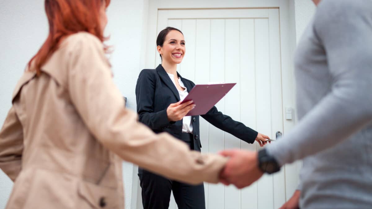 Realtor invites couple to enter a home. She will dictate notes via Athreon's transcription services.