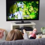 Woman enjoys subtitled nature documentary at home made possible by Athreon's subtitling service.