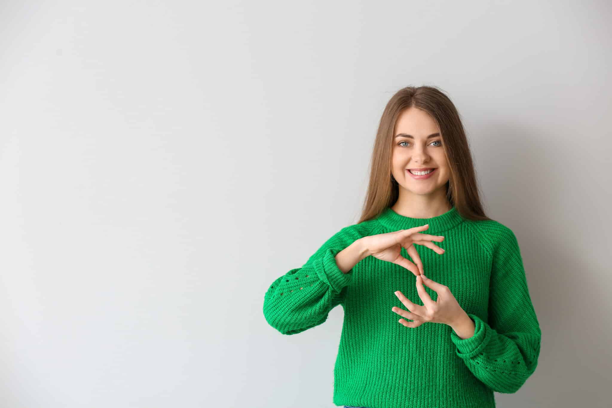 Young deaf woman signs, spotlighting accessibility made possible via video transcription companies.