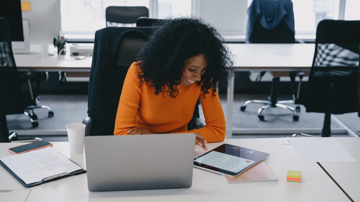 Content creator smiles while she leverages podcast transcripts to create engaging digital content.