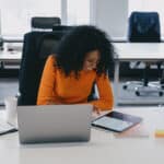 Content creator smiles while she leverages podcast transcripts to create engaging digital content.