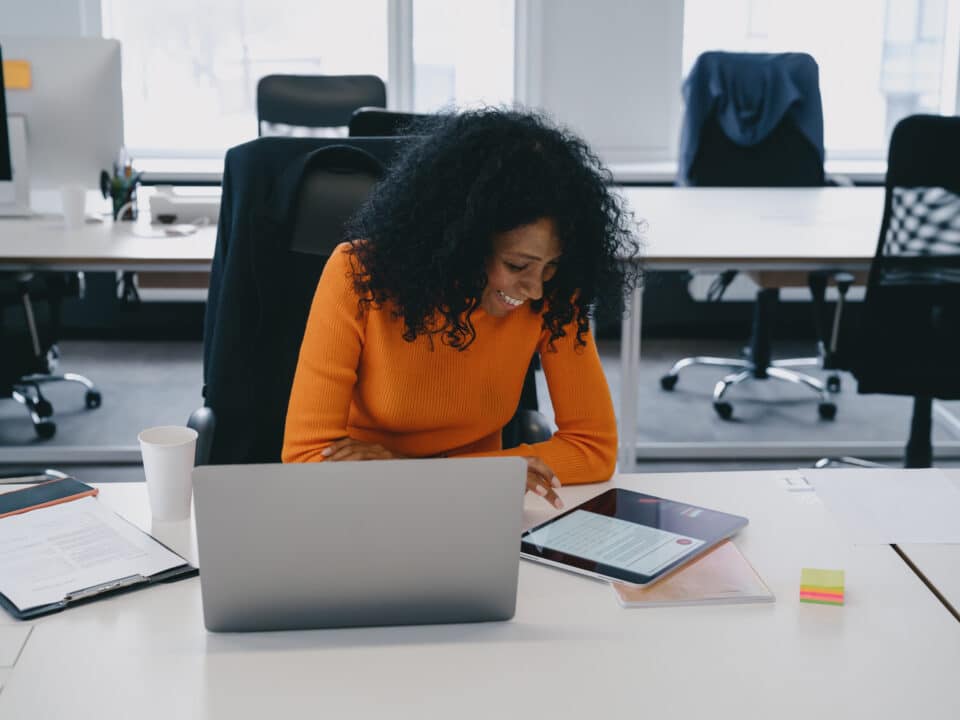 Content creator smiles while she leverages podcast transcripts to create engaging digital content.