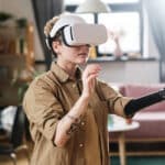 Deaf woman in VR headset uses prosthetic arm and captions in video game.