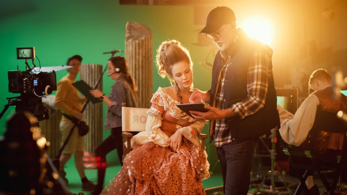 Director holding tablet discusses scene details with actress, showing role of transcription on set.