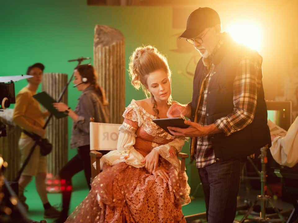 Director holding tablet discusses scene details with actress, showing role of transcription on set.