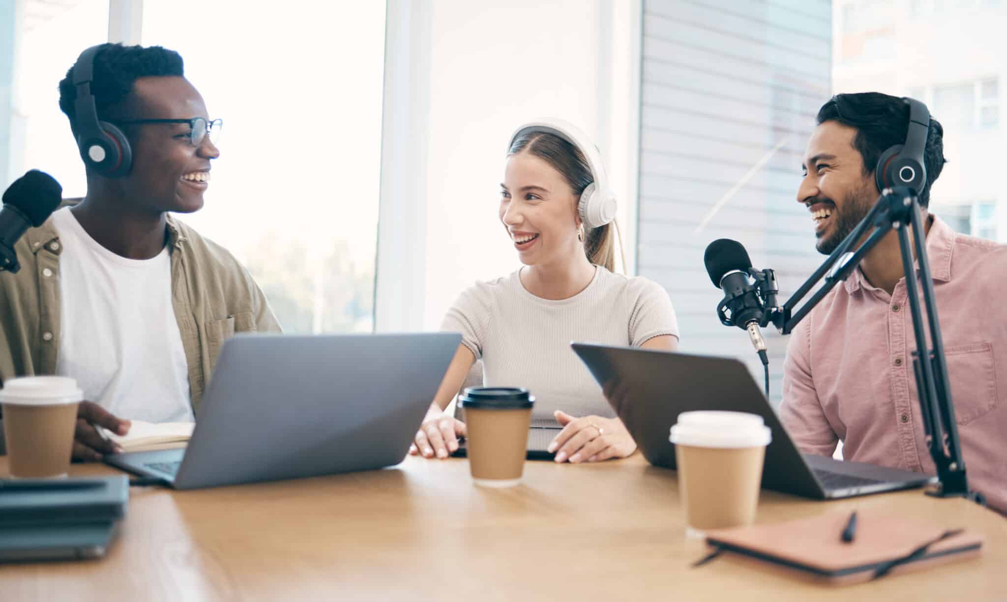 Two men and a woman enjoy a happy podcast discussion, leveraging the benefits of podcast transcripts