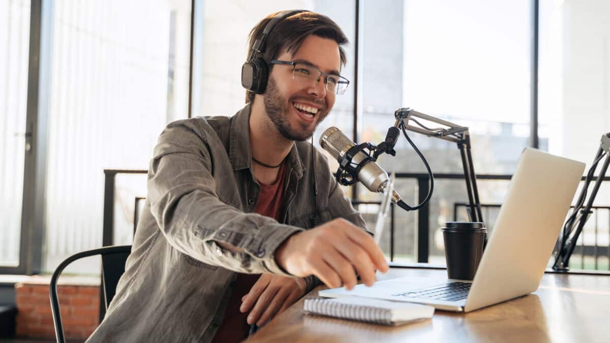 Young male podcaster in a studio session uses transcription services to enhance his podcast's reach.