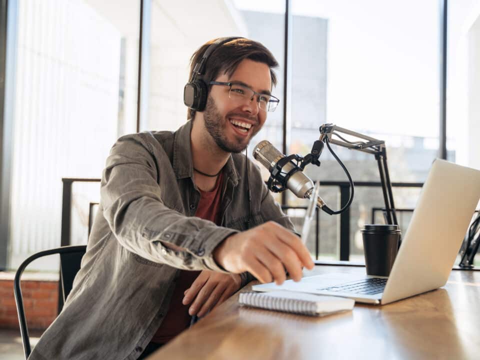 Young male podcaster in a studio session uses transcription services to enhance his podcast's reach.