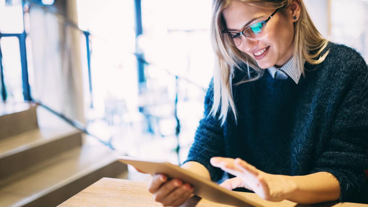 Young woman reads an eBook, enriched with content transcribed by a video transcription company.