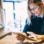 Young woman reads an eBook, enriched with content transcribed by a video transcription company.