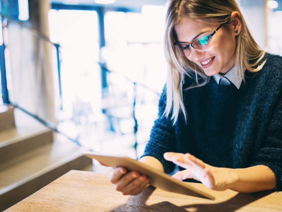 Young woman reads an eBook, enriched with content transcribed by a video transcription company.