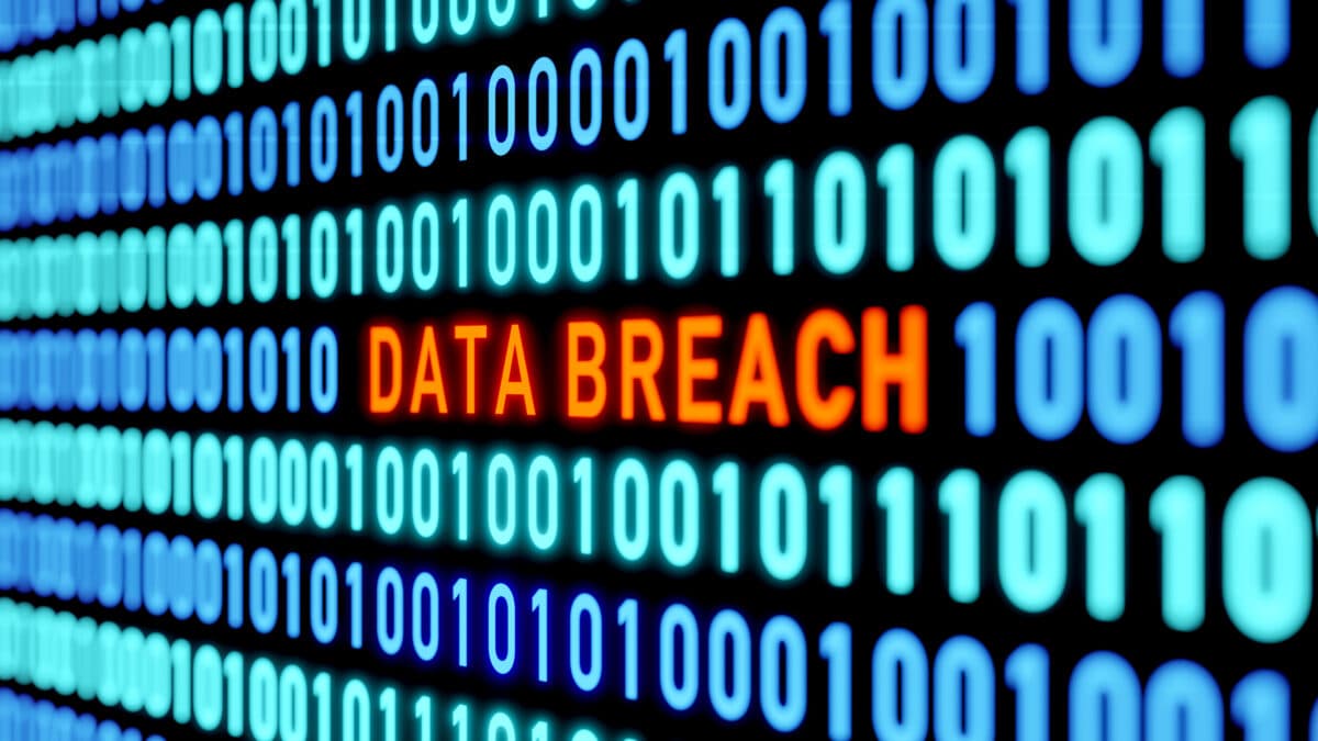 Data breach alert on screen with binary code, emphasizes need for employee cyber security training.