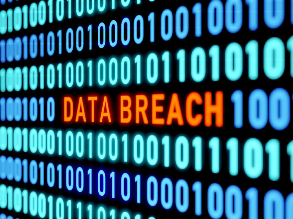 Data breach alert on screen with binary code, emphasizes need for employee cyber security training.