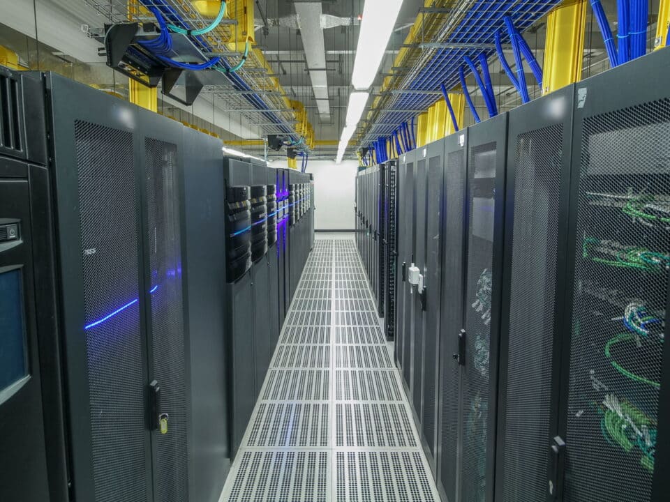 Modern data center with rows of server racks, symbolize the importance of backing up critical data.