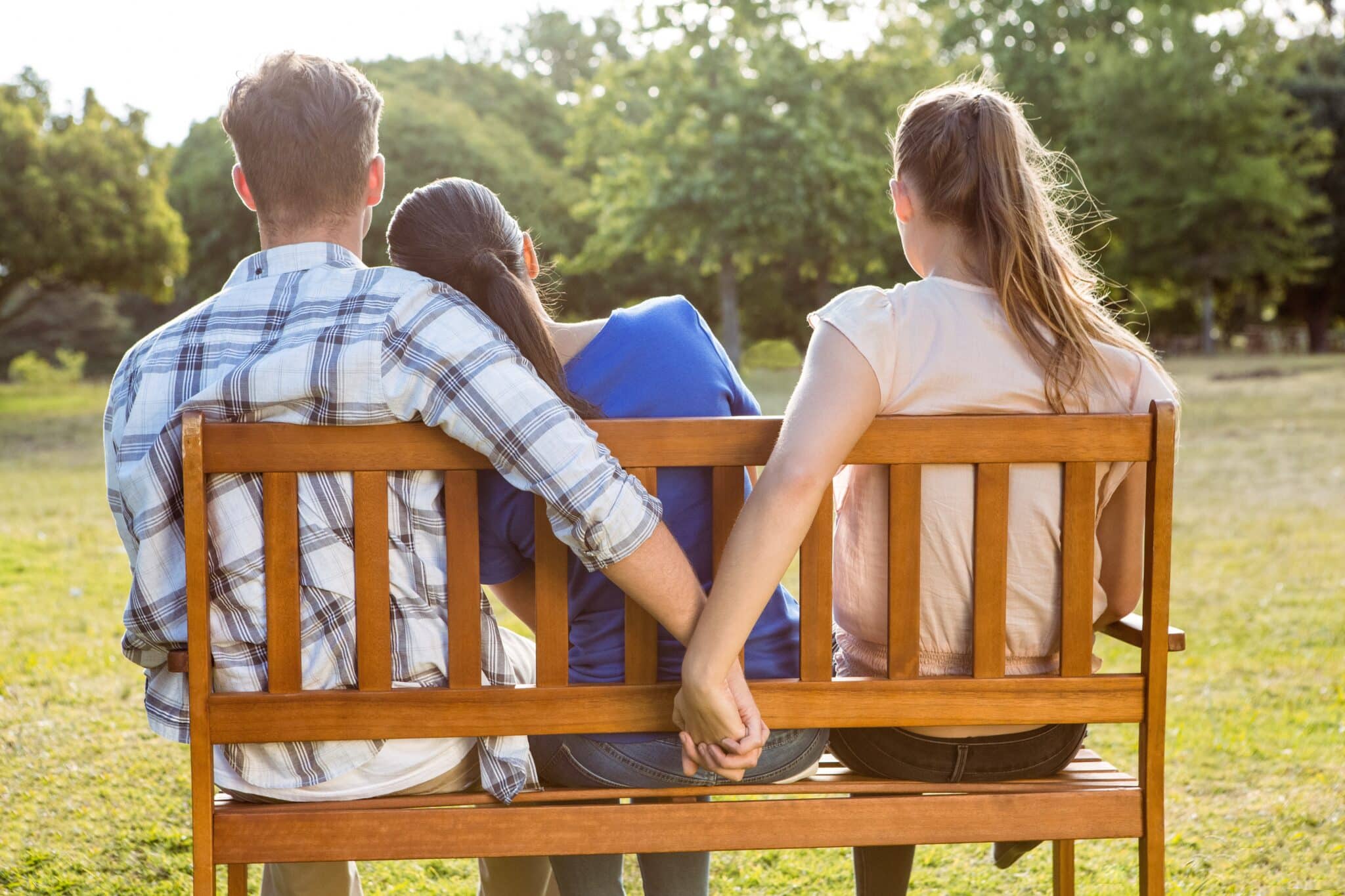 Man stealthily holds hands with 2 women; symbolizes infidelity, Ashley Madison data security lessons